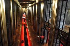 the long hallway is lined with red and black striped carpeted walls, along with large windows