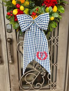 a blue and white gingham bow with the letter d is hanging on a door