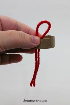 a hand is holding a piece of yarn with the letter q on it's end