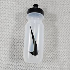 a nike water bottle sitting on top of a white blanket