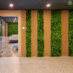 a living room with green plants on the wall and wooden slats in front of it