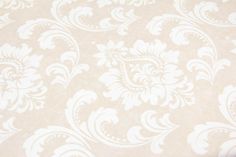 a close up view of a white and beige wallpaper with an ornate design on it