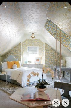 an open book is sitting on a table in front of a bed with yellow and white wallpaper