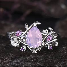 a pink ring with leaves and stones on it