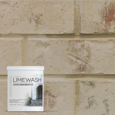 a brick wall with a sign on it that says limewash in front of it