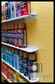 the shelves are filled with different types of paint