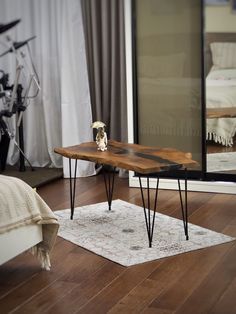 a wooden table sitting on top of a hard wood floor next to a white rug