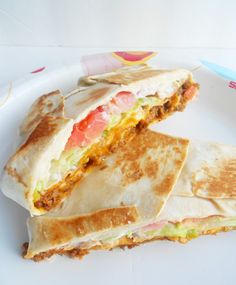 a white plate topped with two quesadillas on top of a paper plate