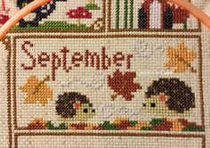 a close up of a cross stitch pattern on a hoop with the words, september