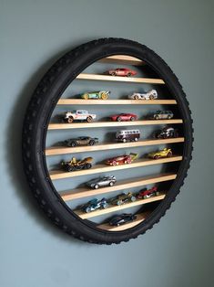 a wall mounted toy car display in a circle shaped frame with wooden slats on the sides