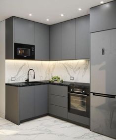 a kitchen with grey cabinets and marble counter tops