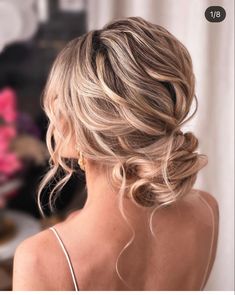 the back of a woman's head, with blonde hair styled into a low bun