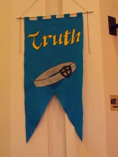 a blue banner hanging from the side of a door that says truth with a white surfboard on it