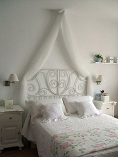 a white bed sitting in a bedroom next to a window