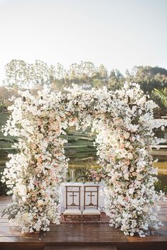 an outdoor ceremony setup with white and pink flowers