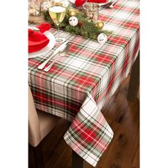 the table is set for christmas dinner with red and green plaid napkins on it