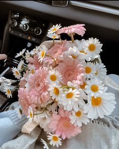 a bouquet of white and pink daisies in the passenger seat