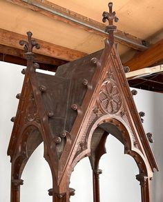 an old wooden structure with ornate carvings on the top and sides, in a building