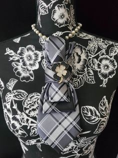 This Black and White Plaid Necktie Necklace is made with a (Barry Wang) woven silk tie, and features a Black and Gold Rhinestone Clover Brooch strung on your choice of an adjustable Rosary Chain Ribbon Tie Pearl Necklace or an adjustable Elastic Band. The soft, comfortable fabric sits perfectly on any size chest, while the adjustable necklace feature allows you to customize the fit to your liking. Measuring at a versatile length, this necktie necklace is designed to be a one-size-fits-all. View Women Ties, Tie Necklace, Handmade Beaded Necklaces, Brooch Necklace, Gold Rhinestone, Womens Tie, White Plaid, Adjustable Necklace, Silk Ties