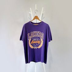 90s Los Angeles Lakers NBA t-shirt/ L * PLEASE READ BEFORE PURCHASE * PLEASE consider the PHOTOS before making the decision * The images may DIFFER in appearance from the actual product because we took pictures under daylight.  * PLEASE send your PHONE NUMBER after your purchase for the shipping company to contact you X No returns X No refund Condition : 9/10 More details : look at the pictures  Brand :  Size on tag : L Pit to pit/ Chests : 22/44 inches  Length : 29 inches  Material : cotton   Color : purple  * ALL ITEMS are VINTAGE which may show some signs of wear and tear * Due to the different display and different light, the picture may not reflect the actual color of the item Thank you RG/24/10/23 Throwback Basketball Crew Neck T-shirt, Throwback Basketball T-shirt With Crew Neck, Throwback Basketball T-shirt With Short Sleeves, 90s Purple T-shirt With Letter Print, 90s Style Purple T-shirt With Letter Print, Purple 90s Style T-shirt With Letter Print, Vintage Purple T-shirt With Letter Print, 90s Los Angeles, Nba T Shirts