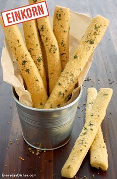 a bucket filled with bread sticks next to a sign that reads, einkorn