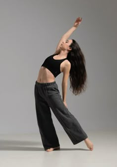 a woman in black shirt and pants doing a dance pose