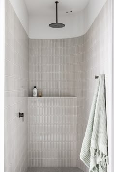 a white tiled bathroom with black and white accessories