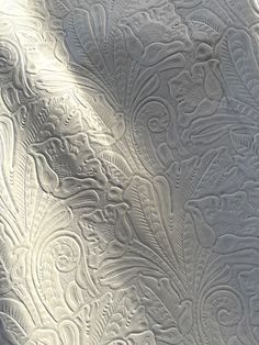 an intricately designed metal surface with white paint