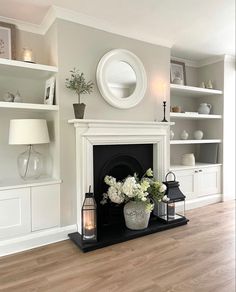 a living room filled with furniture and a fire place next to a white fireplace mantel