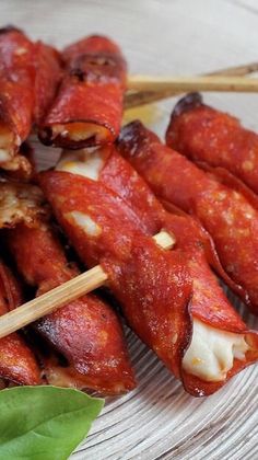 several skewers of food on a plate with chopsticks