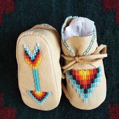 "Native American made baby moccasins with an arrow design on the sole representing a straight true life path. Deerskin Leather is the ultimate in softness and texture because of its tendency to quickly mold to the shape of the foot. Authentic Native Made moccs are beaded in the traditional way, with all seed beads sewn on by hand with strong nylon thread for durability. For more shoe options please visit my shop at: https://www.etsy.com/shop/AuthenticNativeMade FOR ALL ORDERS: Please measure the Beaded Baby Moccasins, Baby Boy Moccasins, Baby Moccasin Pattern, Native American Moccasins, Moccasin Pattern, Leather Baby Moccasins, Baby Moccs, Beaded Moccasins, Bead Sewing