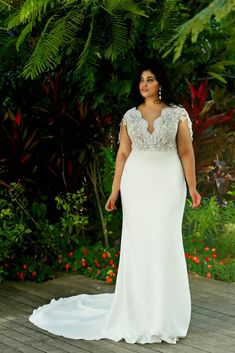 a woman in a wedding dress standing on a deck