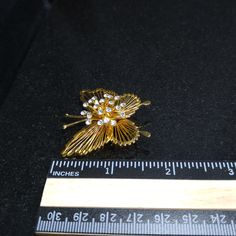 *Description: This is a beautiful Monet gold plated gilded butterfly brooch with raised crystal clear rhinestones in the center. This is a beautiful open wire butterfly, very feminine, and a great figural, light weight, rhinestone brooch. The brooch was in circulation beginning in the 1970s and was designed in three sizes. This brooch would be a great addition to a jacket, hat, or bag. It would also make a great vintage gift. *Approximate Measurements: Length & Width - 1 3/4 Inches *Conditio Gold Brooches With Rhinestones For Anniversary, Gold Brooches With Rhinestones For Evening, Gold Butterfly Brooch For Formal Occasions, Vintage Gold Brooches With Rhinestones, Gold Butterfly Brooch For Party, Gold Butterfly Brooches For Wedding, Gold Butterfly Brooch For Wedding, Wire Butterfly, Formal Earrings