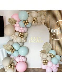 balloons are arranged in the shape of an arch with gold leaves and pink, blue, and white balloons