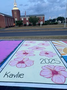 a large sign with flowers painted on it in front of a church