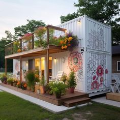 a house made out of shipping containers with flowers on the balcony and balconies