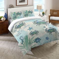 a bed room with a neatly made bed and ocean themed comforter set on it