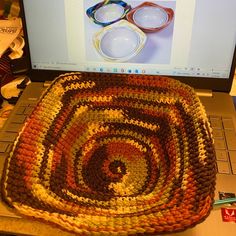 a crocheted rug sitting on top of a laptop computer next to a pair of glasses