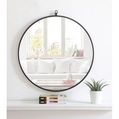 a living room with a white couch and a round mirror on the wall above it