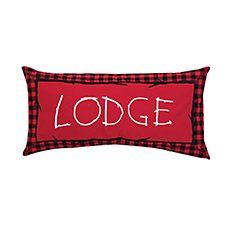 a red and black plaid pillow with the word lodge on it's front side