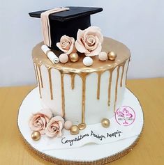 a graduation cake with flowers and a book on the top is ready to be eaten