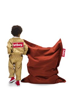 a little boy standing next to a big bag