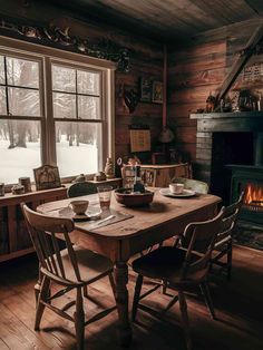 a dining room table with plates and cups on it in front of a fire place