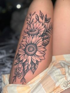 a woman's legs with sunflowers and leaves on them