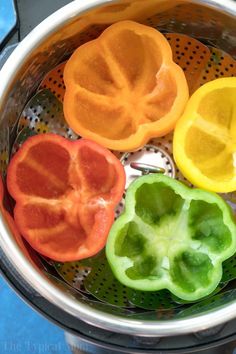 four peppers in a strainer on a blue surface