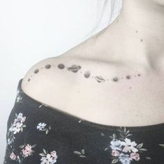 a woman with black dots on her chest and shoulder is wearing a flowered top