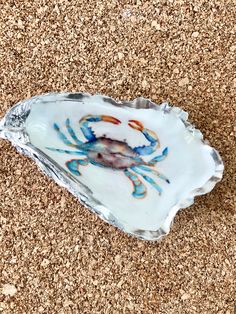 a blue and white crab on an oyster shell