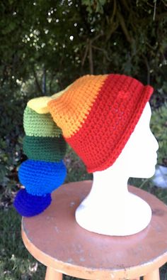 three crocheted hats on top of a white mannequin head