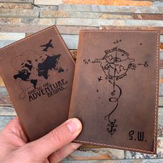 two handmade leather wallets with an adventure map on them