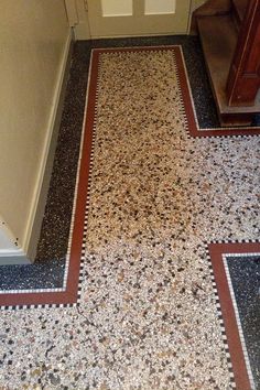 a bathroom floor that has been decorated with different colors and patterns on it, along with a toilet